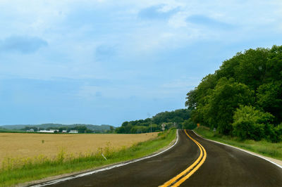 Road passing through landscape against sky