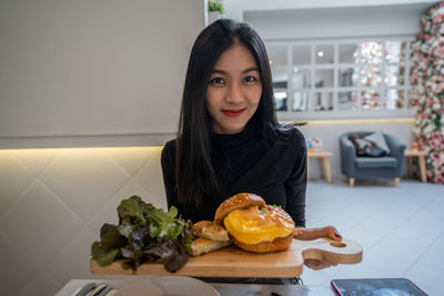 Portrait of young woman sitting at table