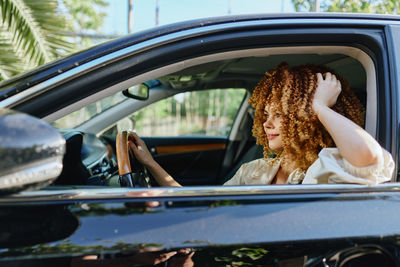 Portrait of young woman sitting in car