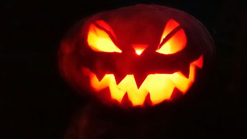 Close-up of lit candle in dark background