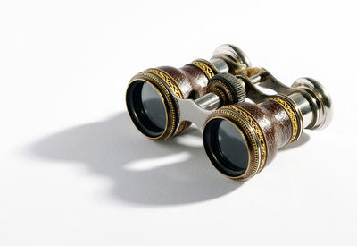 Close-up of old binoculars against white background