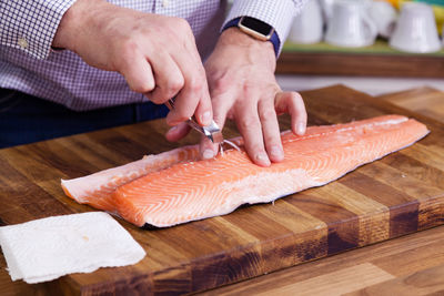 Cropped image of man cleaning fish