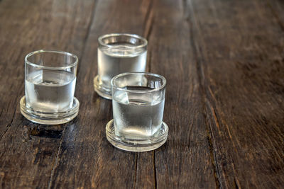 Close-up of drinking glasses on wooden table