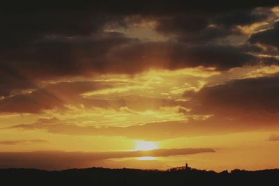 Silhouette of landscape against cloudy sky