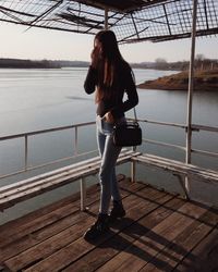 Full length of woman standing by lake