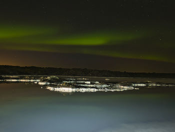 Scenic view of lake against sky at night