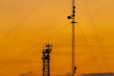 Low angle view of crane against sky during sunset