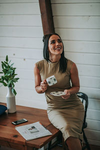 Woman drinking coffee while sitting on table