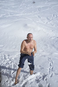 Portrait of shirtless man in snow