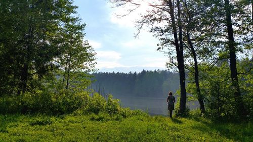 Man standing by tree against sky