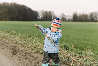 Girl standing on land against field