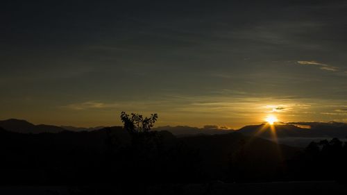 Scenic view of silhouette mountains against sky at sunset