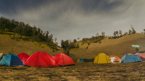 Tent on field by mountain against sky