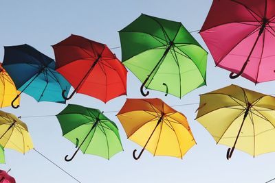 Low angle view of umbrellas hanging against sky