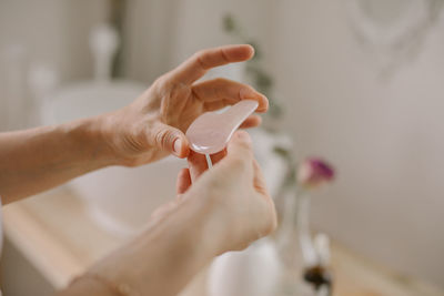 Cropped hand of woman holding jade roller