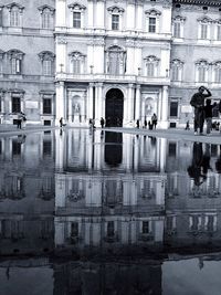 Reflection of people on building in city