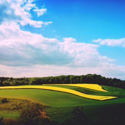 Scenic view of field against cloudy sky