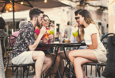 Friends having drinks while sitting at cafe