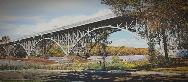 Bridge over river against sky during autumn