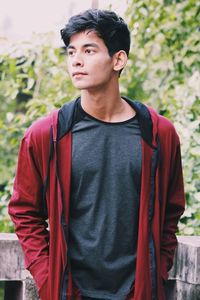 Young man standing against tree