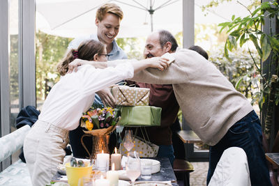 Side view of playful father and daughter enjoying birthday party at restaurant