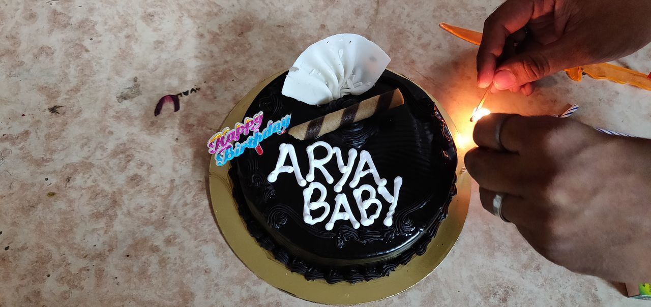 HIGH ANGLE VIEW OF HANDS HOLDING CAKE