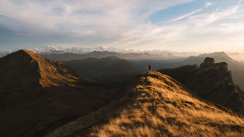 Scenic view of mountain range against cloudy sky