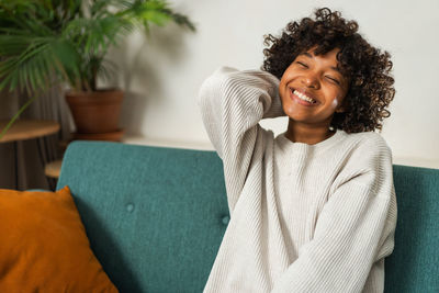 Young woman sitting on sofa at home