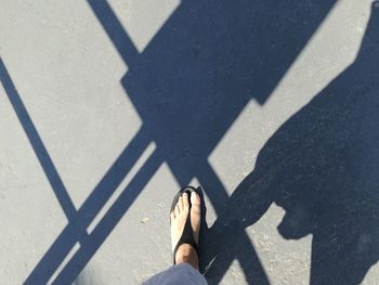 Low section of woman standing on road