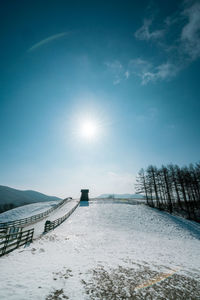 Scenic view of snow covered land against sky