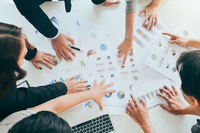 High angle view of people hands on table