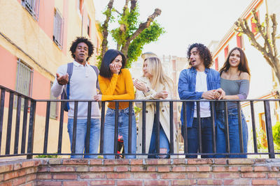 Portrait of smiling friends standing in city