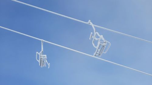 Low angle view of lighting equipment against blue sky