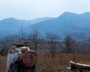 Abandoned truck on field by mountains against sky