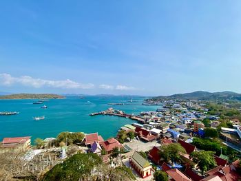 High angle view of townscape by sea against sky