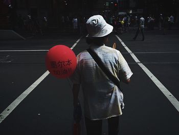 Woman standing on road in city