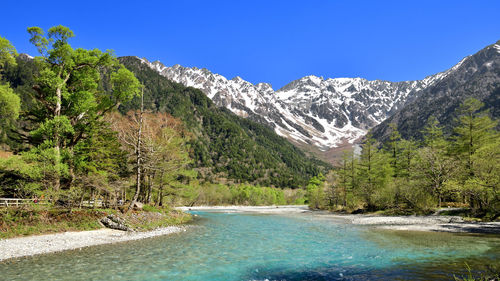 Scenic view of mountains against clear blue sky
