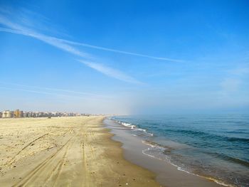 Scenic view of beach against blue sky