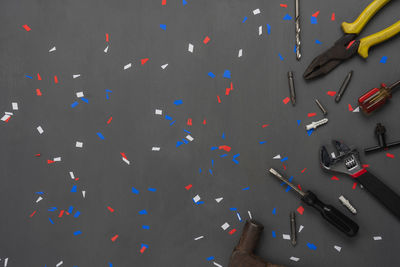 Directly above shot of tools with confetti on table