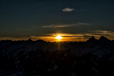 Scenic view of snowcapped mountains against sky during sunset