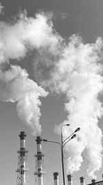 Low angle view of smoke emitting from chimney against sky