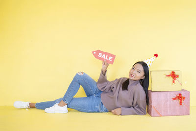 Young woman lying down against gray background