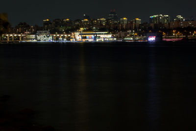 Illuminated modern buildings by han river against sky in city at night