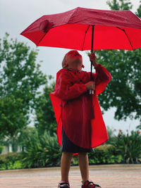 Rear view of boy holding umbrella