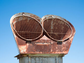 Low angle view of old sunglasses against clear blue sky