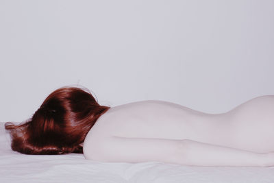 Redhead woman lying on bed