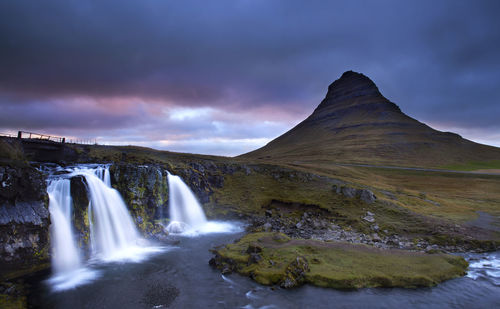 View of waterfall with mountain in background