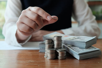 Close-up of hand holding stack of objects on table