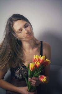 Portrait of young woman holding flowers
