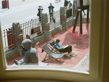 High angle view of people sitting on seat in city